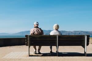 An elderly couple sitting watching the mountains