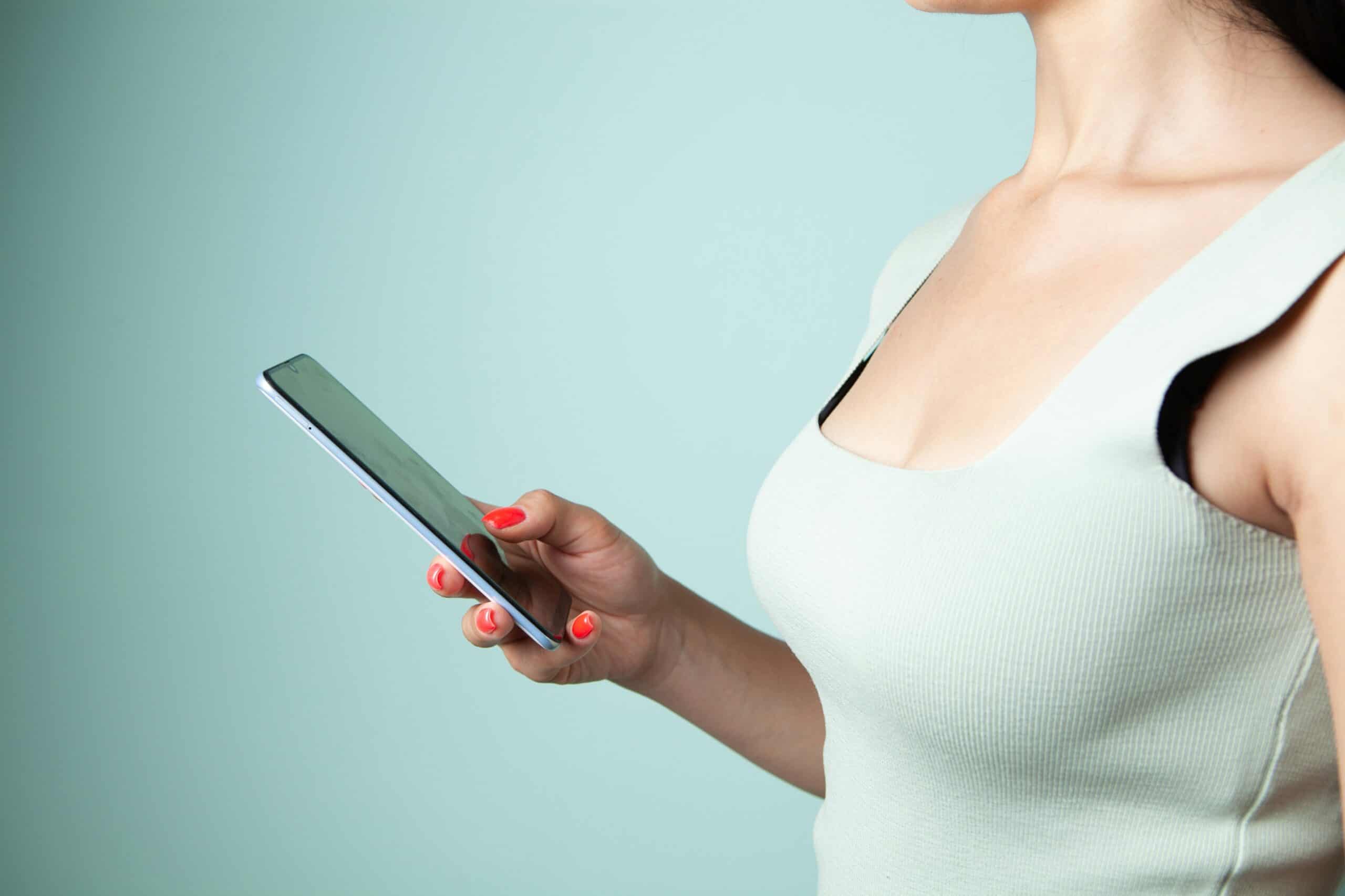 women holding and watching at a smartphone