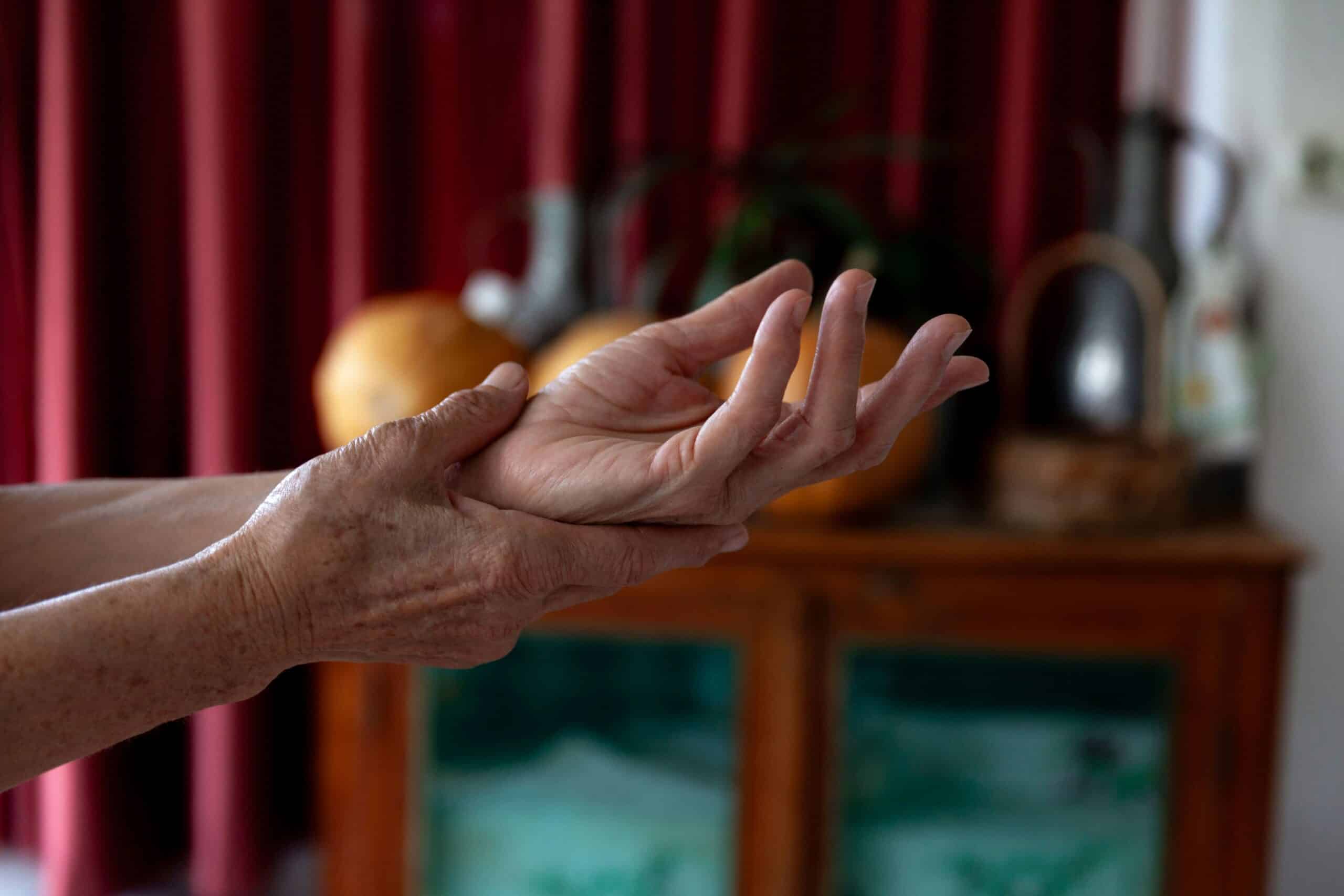 an elderly woman touching her hands